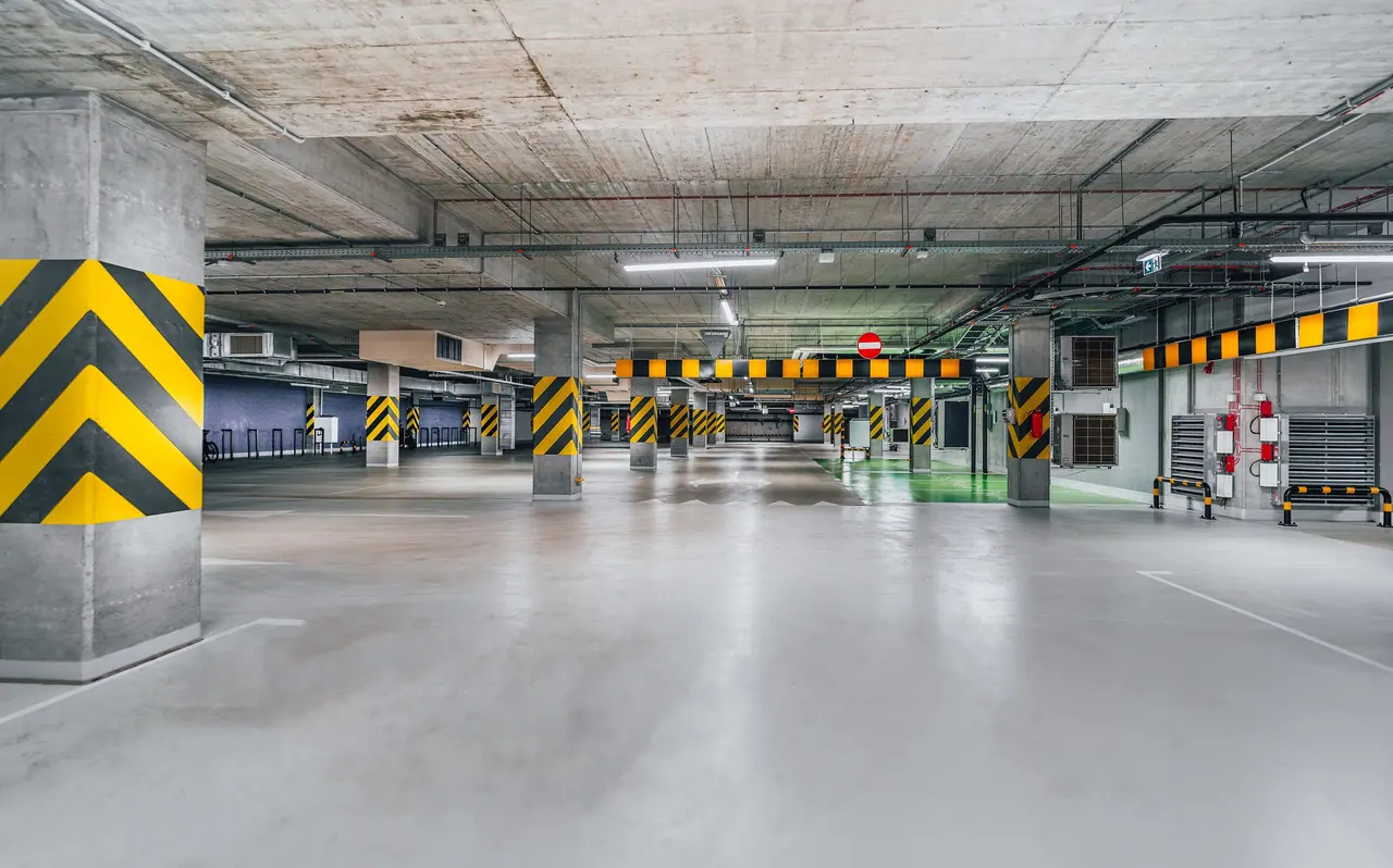 Garagem industrial com faixas de segurança e piso cinza
